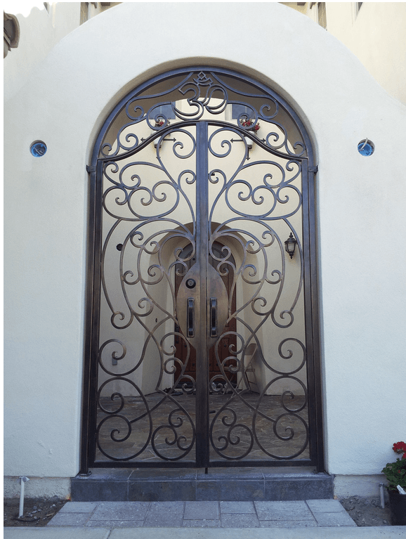 Ornate wrought iron double doors within an arched entry.